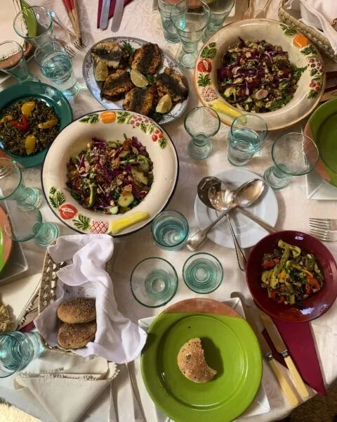 Shared dishes and turquoise glasses on a lunch table during the Marrakech site visit