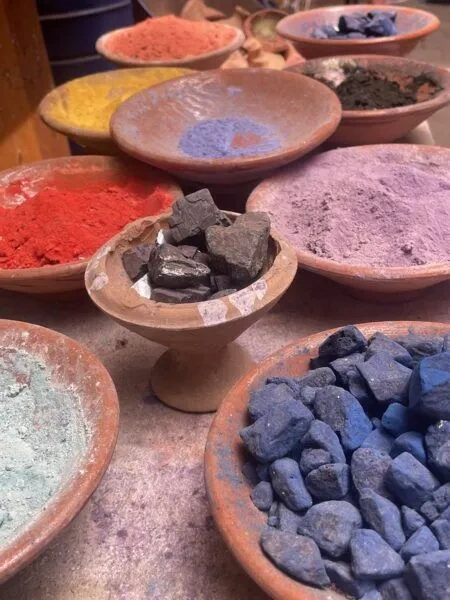 Terracotta bowls filled with colourful powders and stones at a Marrakech market stall