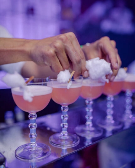 Creative cocktails with candy-floss clouds are prepared on a bar for an immersive party by Sauveur Studios.
