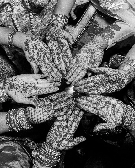 Mehndi artwork on guest hands at an Indian wedding delivered by luxury event management specialists, Sauveur Studios.
