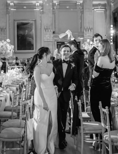 A couple entering dinner at a wedding produced by luxury wedding planner Sauveur Studios.
